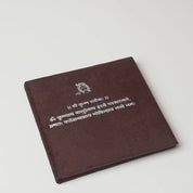 Unboxing the Blessings in Silver Radha Krishna edition: velvet shloka folder opened to reveal the 5 gm 999 silver Radha Krishna coin