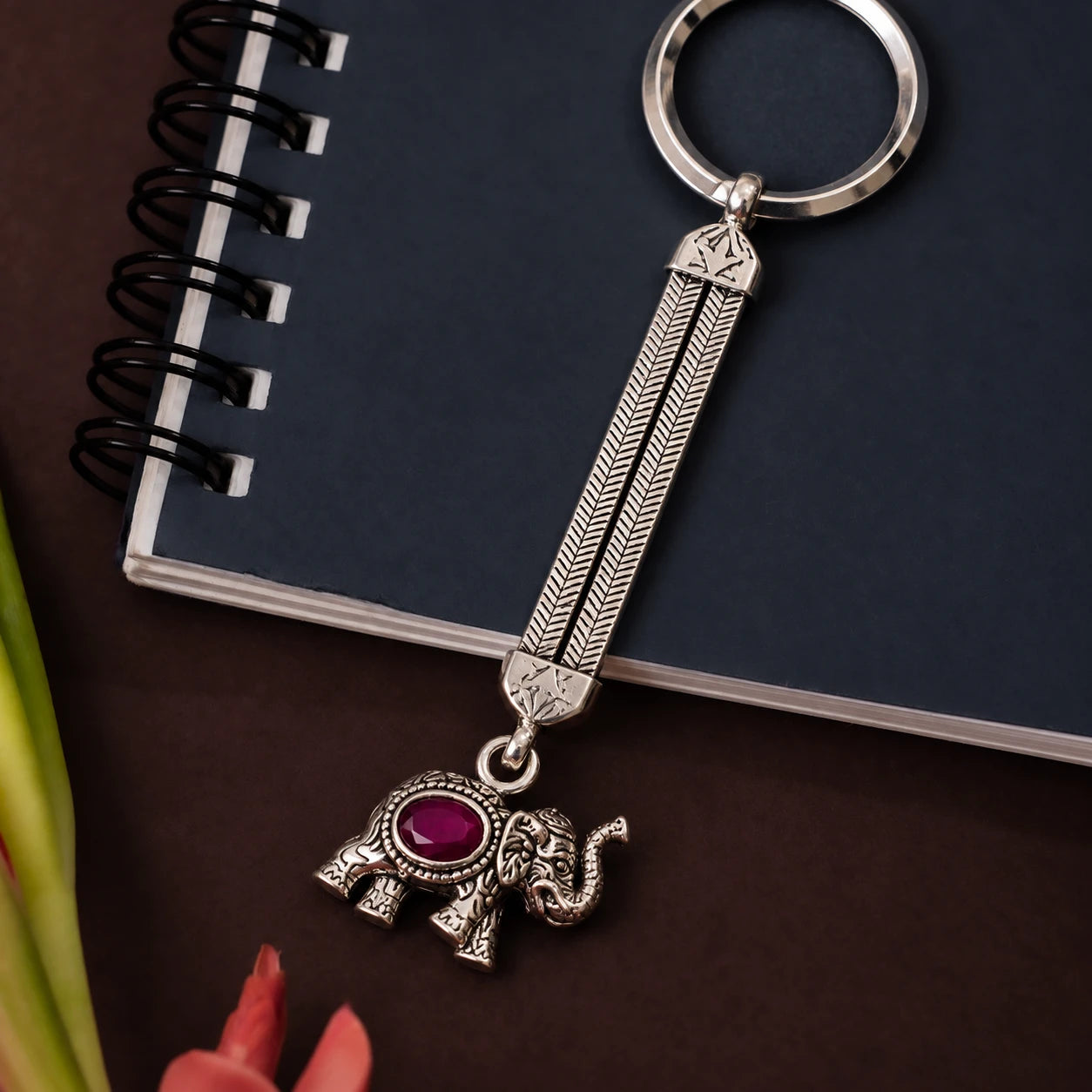 Regal elephant silver keychain styled on a notebook