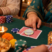 Silver poker chip placed on playing cards at a Diwali card night