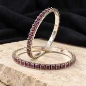 Square-set red stone silver bangles, styled