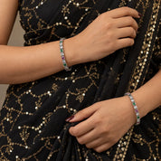 Square-set multicolour silver bangles worn on the wrist